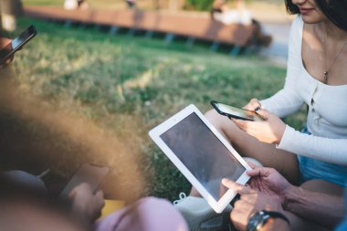 Sosyal ağ kurma, kırpılmış erkek ve kadın milenyumları web dosyalarının paylaşımı için bluetooth bağlantısı kullanarak kablosuz internet sitelerini taramak için akıllı telefon ve boş dokunmatik cihazlar tutan insanlar