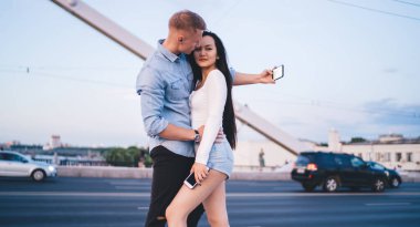 Yakışıklı, beyaz bir erkek, çekici bir kız arkadaşla randevulaşırken video bloğunu etkiliyor. Şehir köprüsünde cep telefonunun ön kamerasını kullanıyor. Milenyum çifti birbirine aşık.