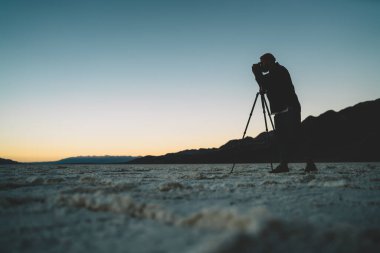 Üç ayaklı bir adamın gölgesinde fotoğraf çekilirken akşam ABD 'de Ölüm Vadisi' nde vakit geçirirken çekilmiş.