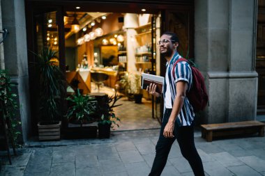 Düşünceli koyu tenli erkek, elinde modern dijital tabletle caddeleri keşfediyor. Yakışıklı 20 'li yaşlarda, Afro-Amerikan hipster erkek. Hafta sonu tabletleriyle geziyor.