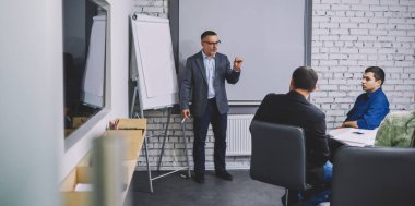 İşletme projesi için bilgi açıklayan profesyonel ekonomist, başarılı iş adamları şirket sunumunda danışmanlığı tartışırken birlikte iş birliği yapıyorlar