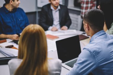 Profesyonel yöneticilerden oluşan bir grup, dizüstü bilgisayarda fotokopi alanı olan internet yayınları için finansal reklam metni hakkında iletişim kuruyor, erkek ve kadın ortaklar iş stratejisini tartışıyor