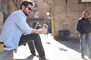 Ciddi sakallı turistlerin günlük kıyafetleri ve güneş gözlükleriyle bahçedeki merdivenlerde dinlenirken tarihi binalarla çevrili ve gözlerini başka yöne çevirmiş...