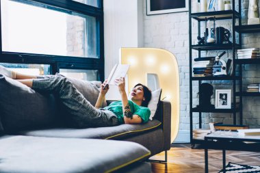 Beyaz kadın, edebiyat okumak için boş vakitlerini harcıyor. Hafta sonu en çok satanlar listesinde şık bir tasarımı olan evde. Eğitimde kitap okuyan çekici bir kadın, düz bir koltukta uzanıyor.