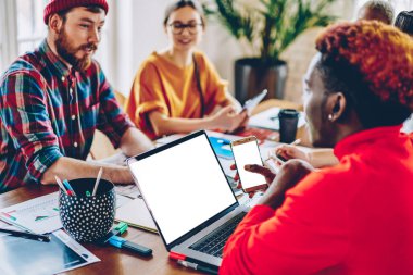 Koyu tenli bir çalışan, iş reklamları için fotokopi alanı ile modern mobil ve netbook teknolojisi kullanıyor. Boş cep telefonuyla erkek ve kadın meslektaşlarıyla iletişim kuran yetenekli bir serbest yazar.