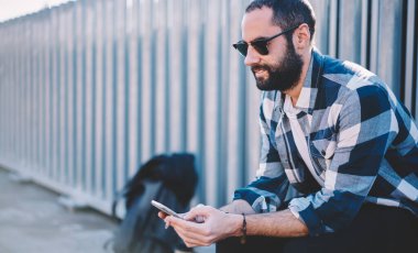 Kötü alışkanlıklardan kurtulmak için internet ipuçlarıyla el gezen nikotin sigaralı Ortadoğulu erkek turist, güneş gözlüklü Türk sigara tiryakisi e-posta mesajı aldı ve metin yazdı