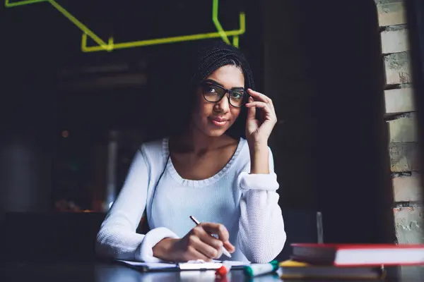 Young Dreamy African American Female Student Looking Camera Touching Frame Stock Photo