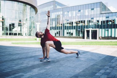 Ciddi erkek sporcuların tüm vücudu sabah egzersizleri yaparken sağlıklı bir yaşam sürüyor ve şehir merkezindeki eğitimin tadını çıkarıyor.