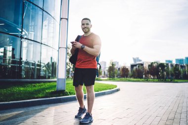 Şehirdeki kaldırımda dikilip kameraya bakarken cep telefonuyla erkek turistlerin mesajlaşmasının tam uzunluğu