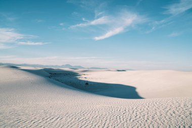 Beyaz kum tepeleri ve mavi gökyüzü olan çöl manzarası Amerika 'daki White Sands Ulusal Parkı' nda sakin bir gün.