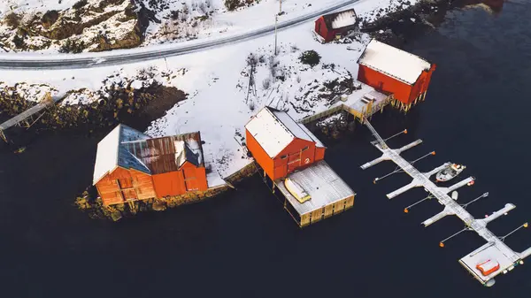 Norveç deniz suyuyla kaplı Lofoten takımadalarının nefes kesici kuş bakışı görüntüsü. Küçük balıkçı teknesinin hava görüntüsü. Altın gün batımında iskelesi olan. 