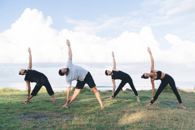 Yoga yapan çok kültürlü sporcular iç huzuru ve canlılığı hissediyorlar. Hatha asana 'da duran esnek vücutlu kadın ve erkek fiziksel ve zihinsel sağlığa önem veriyor.