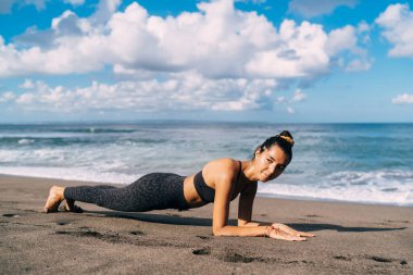 Sağlıklı yaşam tarzı ve motivasyon konsepti, çekici Ortadoğulu bayan sporcu sabah antrenmanı için zamanını kıyı şeridinde harcıyor.