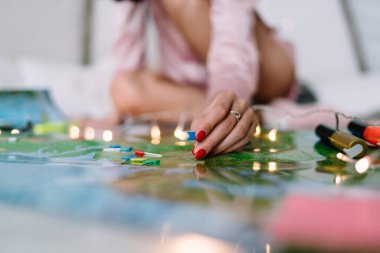 Rusya haritasında işaret levhalarıyla işaret eden kadınların seçici odak noktası. Yerde oturan ve pijama giyen bir kızın bulanık görüntüsü. Gelecekte tatil ya da seyahat planlayan kadın