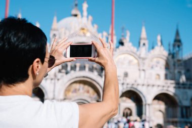 Venedik 'e yaz seyahati sırasında San Marco' nun bulanık resimlerini çeken turist resimleri, İtalyan kentinin mimari binalarını ve video çekimlerini çeken kadın kullanıcı