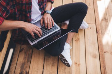 İnternet siteleri üzerinde çalışan dizüstü bilgisayarda erkek yazısının kırpılmış görüntüsü, sosyal ağlarda iletişim kuran yetenekli yazılım programcısı netbook uygulaması ile web tasarımı oluştururken