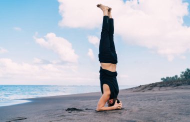 Güçlü erkek atlet, deniz kıyısı sahilinde sabah antrenmanı yaparken, beyaz adam, vücut şeklini mükemmel tutmak için yoga asana yapıyor ve sabah sporunun tadını çıkarıyor.