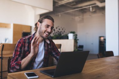 Happy Kafkasyalı adam, modern dizüstü bilgisayarda ön web kamerasıyla çalışırken, video görüşmesine olumlu yanıt veriyor. Neşeli bilişim profesyonel çekim bloğu, programlama işi hakkında konuşuyor.
