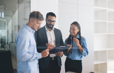 Sermaye stratejisi hakkında fikir alışverişinde bulunan profesyonel uzmanlardan oluşan bir grup, istatistik raporlarından elde edilen bilgileri tartışıyor.
