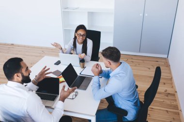 Bir grup profesyonel girişimci ofis içi beyin fırtınası sırasında iş fikirlerini tartışıyorlar. Dizüstü bilgisayarları olan başarılı bir kadın ve erkek ticaret projesi hakkında konuşuyorlar.
