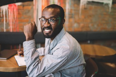 Gözlüklü, gözlüklü, gözlüklü, gözlüklü, üniversitede eğitim gören, gözlüklü, gazetecilik yaparak eğlenen, gözlüklü, mutlu, Afro-Amerikan bir adam.