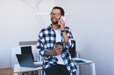 Sıradan giyinmiş başarılı bir adam telefon görüşmeleri sırasında iş görüşmeleri yapıyor. Gözlüklü kaygısız erkek programcı, akıllı telefon teknolojisiyle arıyor. Ofiste kahve molası veriyor.