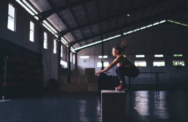 Boks atlama egzersizi yapan atletik bir kadın - Crossfit ve sağlıklı yaşam tarzı konsepti, beyaz eşofmanlı kadın vücut geliştirici, zayıflama ve beden eğitimi için yoğun bir kardiyo eğitimi almış.