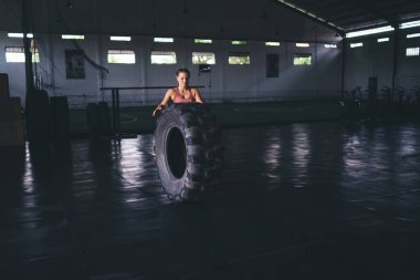 Ağır lastikli kadın vücut geliştirici spor salonu içinde zayıflamak için kardiyo eğitimi almış. Tekerlek teçhizatlı beyaz kadın sağlıklı yaşam tarzını ve canlılığını koruyor.