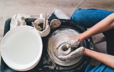 Sanat stüdyosundaki çömlek çarkının üzerinde kadın toprak kalıbının kesilmiş görüntüsü. Küçük işletmeler ve girişimcilik. Ev hobisi, eğlence ve eğlence. Üst düzey kadın görüşü