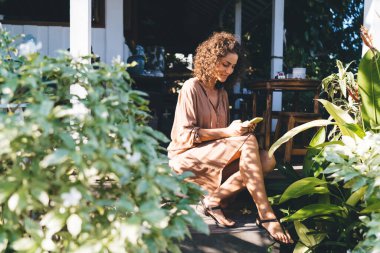 4G 'ye bağlanan genç hippi kız, akıllı telefon uygulaması üzerinden cep telefonu teknolojisi kullanan ve eposta mesajı alan ve mesaj atan bir kadın.