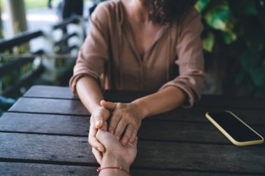 Kesilmiş erkek ve kadın eli, ezoterik ayin sırasında canlı konsültasyon ve yardım sırasında teta bütünsel iyileşmesini tartışırken, tanınmayan insanlar sorunlar hakkında konuşurlar.