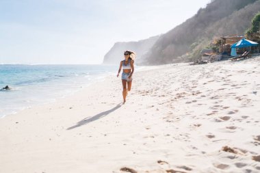 Deniz kıyısında koşan kaygısız kadın - tatil tatili için yaz özgürlüğünün tadını çıkarıyor, Kafkas turistleri güneşli mevsimde Sri Lanka 'yı ziyaret etmek için seyahat ediyorlar.