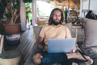 Dizüstü bilgisayarda video izleyen yetenekli bir erkek serbest yazar e-posta mesajı aldı, Kafkasyalı hippi web sitelerini taramak için Netbook aygıtı kullandı ve uzaktan programlama yaptı.