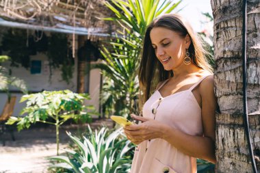 Kafkasyalı 20 'li yaşlardaki hippi kız cep telefonundan 4G kablosuz internete bağlanan e-posta mesajını kontrol ediyor. Milenyum kadın seyahat blogcusu cep telefonu teknolojisine mobil uyarı yüklüyor.
