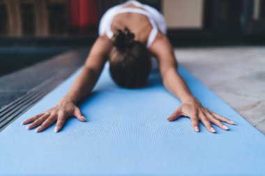 Esnek kadın yogi hatha yapıyor halı halısında vücut kaslarını esnetiyor tonik olarak zayıf vücut figürlerini gösteriyor spor kıyafetleri içinde tanınmayan fit bir kız pilates eğitimi sırasında uyum meditasyonundan zevk alıyor.