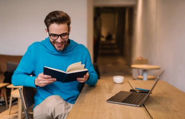 Bluetooth kulaklıkla notlar ve bilgisayar dinleyen neşeli erkek öğrenci eğitim bilgisi, kulaklıklar ve optik gözlük öğrenme konusunda mutlu serbest çalışan