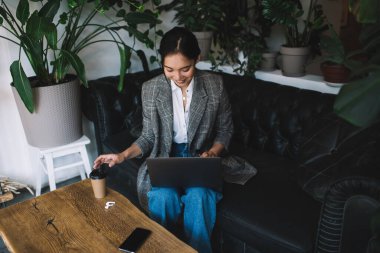 Gündelik kıyafetlerle gülümseyen kadın girişimci iş ortaklarıyla internet üzerinden iletişim kuruyor. Web bağlantısının tadını çıkarıyor, kahveli mutlu Asyalı blogcu mesajlaşmak için mesaj atıyor.