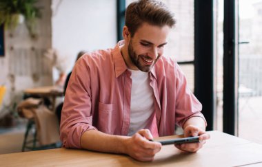 Nintendo konsol teknolojisi ile online oyun oynamaktan keyif alan mutlu beyaz adam, sosyal medyada ağ kurmak için akıllı telefondan 4G 'ye bağlanan neşeli erkek kullanıcı