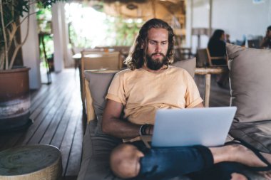 Sosyal medyada video izleyen beyaz tenli metin yazarı, internette internet okumak için dijital ağdaki 4G kablosuz internete bağlanan milenyum erkek bilişim profesyoneli, bağımsız olarak dizüstü bilgisayar kullanıyor.