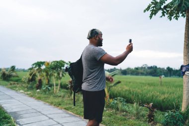 Endonezya 'da seyahat yolculuğunu etkilemek için gopro kamera ekipmanı kullanan turistik sırt çantalı bir videocu, su geçirmez teknolojiye sahip bir adam geziden bahsediyor.