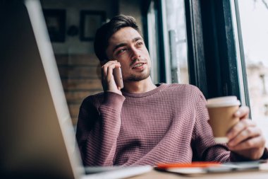 Beyaz erkek programcı akıllı telefon danışmanlık konuşmaları sırasında web tasarımını tartışıyor, dizüstü bilgisayarlı yetenekli hippi adam ve cep telefonu uygulaması kullanarak arama yapıyor.