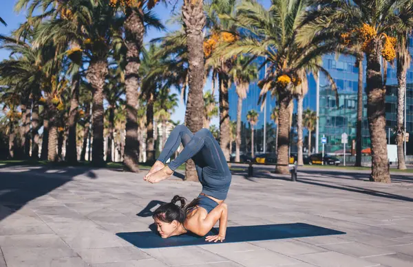 Aktif 20 'li yaşlardaki güçlü Asya' lı kadın ters yoga pozisyonunda duruyor. Nefes alıyor ve Zen 'e ulaşıyor. İnce vücutlu konsantre bir kadın.