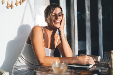 Genç, neşeli kadın dinleniyor ve tatil köyünün terasında güneşli bir günün tadını çıkarıyor. Turizm, tatil ve hafta sonu. Çekici, gözleri kapalı, beyaz bir kız. Bali adasında huzurlu ve huzurlu bir yaşam tarzı