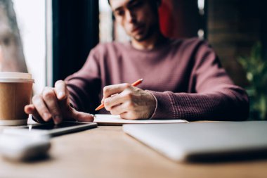 Bulanık erkek öğrenci öğrenimi ve dokunaklı mobil ekran harcaması planlama ve evrak işleri için, ders kitabı ile tanınmayan zeki adam ödev ve üniversite bilgi testi yapıyor.