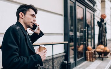 Kafkasyalı hippi bir adam kahve alıp uluslararası gezici sohbetler yapmak için dolaşmaya çıkıyor. Milenyum adamı seyahatle ilgili haberleşmek için akıllı telefon konuşması yapıyor.