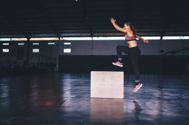 Boks atlama egzersizi yapan atletik bir kadın - Crossfit ve sağlıklı yaşam tarzı konsepti, beyaz eşofmanlı kadın vücut geliştirici, zayıflama ve beden eğitimi için yoğun bir kardiyo eğitimi almış.