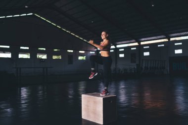 Boks atlama antrenmanında mutlu, formda bir kız antrenmanı sportif spor salonunda, neşeli, Kafkas bir kadın kendini adamış bir şekilde gülümsüyor sağlıklı yaşam tarzının ve canlılığın tadını çıkarıyor.