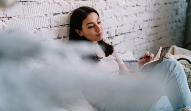 Genç Asyalı kadın evdeki tuğla duvarda otururken deftere yazı yazıyor. Ev hayatı işte. Noel ve yeni yıl zamanı. Bin yıllık neslin genç ve çekici esmer kadını.