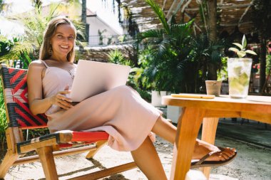 Uzaktan çalışan netbook bilgisayar kullanan mutlu milenyum grafik tasarımcısının portresi, bilgisayarlı ve dijital göçebe ve serbest yaşam tarzından keyif alan neşeli yetenekli kadın metin yazarı.