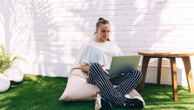 Genç bayan milenyum, dijital netbook teknolojisi ve Kafkasyalı kadın sohbeti hakkında internet bilgilerini eşzamanlı taramak için WIFI internetine bağlanan klasik görüş koruması için klasik göz giysisi.